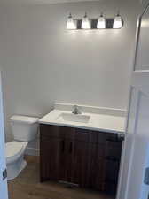 Bathroom featuring toilet, hardwood / wood-style floors, and vanity