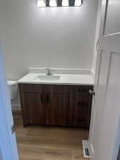 Bathroom featuring vanity, toilet, and hardwood / wood-style floors