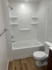 Full bathroom featuring hardwood / wood-style flooring, bathtub / shower combination, toilet, and vanity