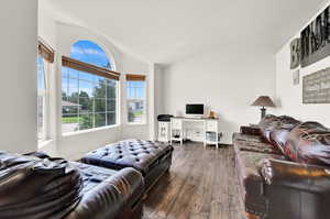 Living room with dark hardwood / wood-style flooring and lofted ceiling