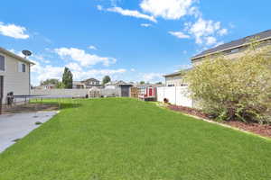 View of yard featuring a trampoline and a storage unit