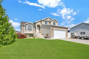 View of front of home featuring a garage and a front lawn