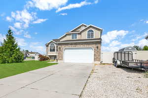 View of property featuring a garage and a front lawn