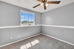 Spare room featuring carpet floors and ceiling fan