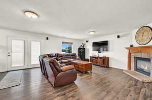 Living room featuring dark hardwood / wood-style floors and a textured ceiling