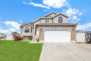 View of front of property with a garage and a front lawn