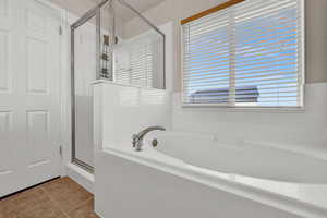 Bathroom featuring separate shower and tub and tile patterned flooring