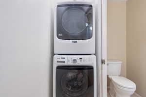 Washroom featuring stacked washer / drying machine