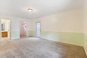 Primary bedroom with crown molding, a walk in closet, light carpet, a closet, ensuite bath and a door to a deck with mountain and valley views.