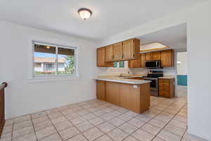 Kitchen casual dining area featuring light tile floors and a new window with farmhouse-style trim.