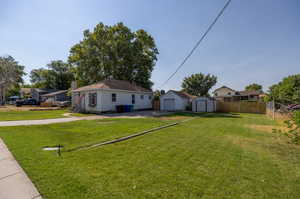 View of front of house featuring a front lawn and a storage unit