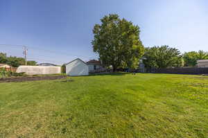 View of yard featuring a playground and a storage unit