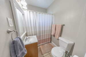 Bathroom featuring tile patterned flooring, toilet, and vanity