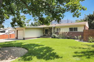 Ranch-style home featuring a garage and a front yard