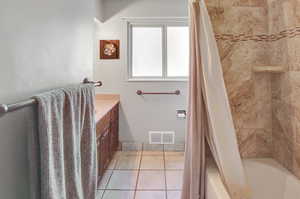 Bathroom featuring vanity, tile patterned flooring, and shower / bath combo