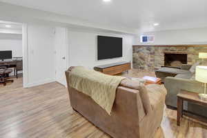 Living room with a fireplace and light wood-type flooring