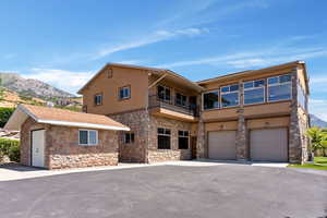 View of front facade with a balcony, a garage, and a mountain view