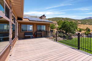 Deck featuring a mountain view and a lawn