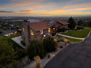 View of front of property featuring a lawn and solar panels