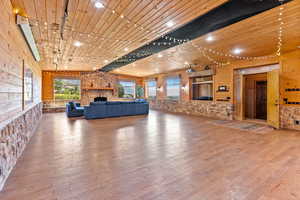 Entertainment room with a fireplace, hardwood / wood-style floors, and wood ceiling