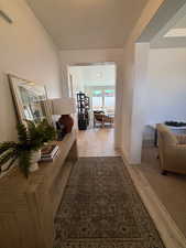 Hallway with a textured ceiling and light hardwood / wood-style floors