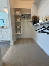 Walk in closet featuring sink and carpet