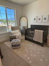 Bedroom with a textured ceiling, a mountain view, a nursery area, and carpet floors