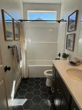 Full bathroom featuring shower / bath combo, vanity, tile patterned flooring, and toilet