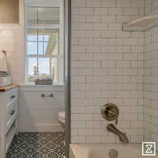 Bathroom featuring vanity, toilet, tile patterned floors, and tile walls