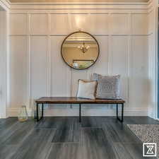 Mudroom with dark wood-type flooring, a chandelier, and ornamental molding