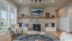 Living room featuring a stone fireplace and light hardwood / wood-style flooring