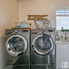 Washroom with independent washer and dryer, sink, and cabinets