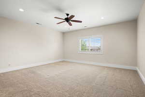 Carpeted spare room featuring ceiling fan