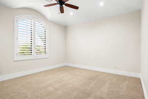 Carpeted empty room featuring ceiling fan