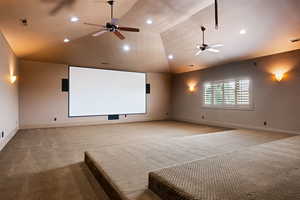 Cinema room with light colored carpet, lofted ceiling, and ceiling fan