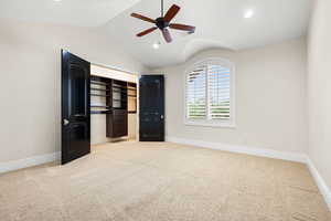 Unfurnished bedroom with light carpet, ceiling fan, lofted ceiling, and a closet