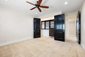 Unfurnished bedroom featuring light carpet, a closet, and ceiling fan