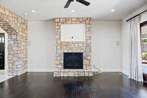 Unfurnished living room featuring a fireplace, hardwood / wood-style flooring, and ceiling fan