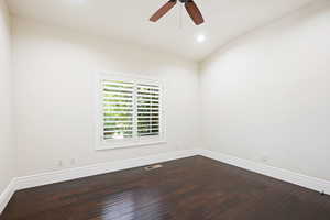 Unfurnished room featuring hardwood / wood-style flooring, vaulted ceiling, and ceiling fan