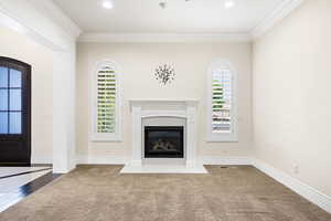 Unfurnished living room featuring crown molding and hardwood / wood-style floors