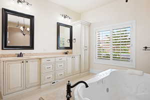 Master Bathroom Bathroom with tile patterned flooring, an inviting chandelier, a bathtub, and dual bowl vanity