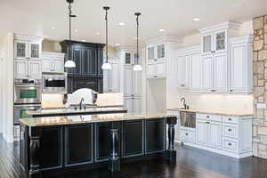 Kitchen with appliances with stainless steel finishes, wood-type flooring, and a kitchen island