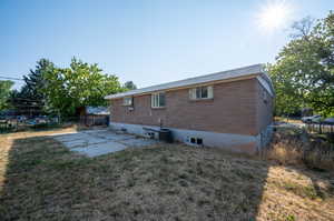 Rear view of house featuring central air condition unit, a yard, and a patio area