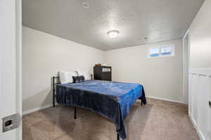 Bedroom with light carpet and a textured ceiling