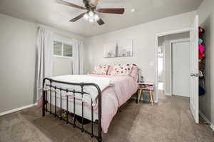 Carpeted bedroom featuring ceiling fan