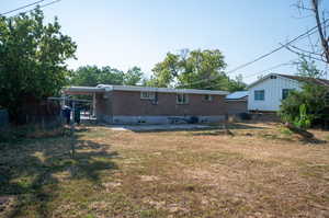 Rear view of house featuring a lawn