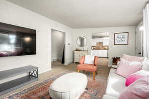 Carpeted living room featuring a notable chandelier