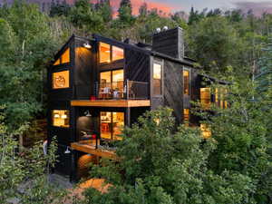 Back house at dusk featuring a balcony