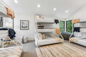 Carpeted bedroom featuring lofted ceiling