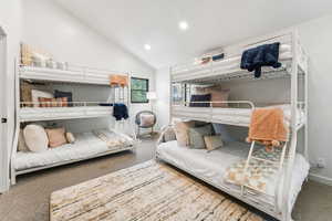 Carpeted bedroom featuring vaulted ceiling